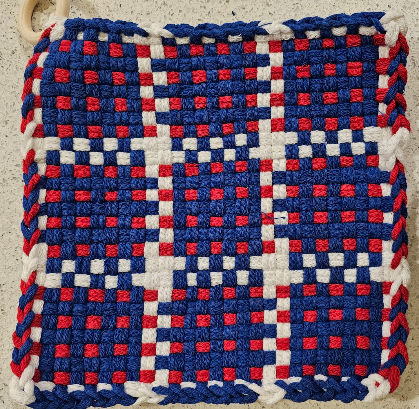 Woven potholder with a checkered pattern in red, white, and blue 