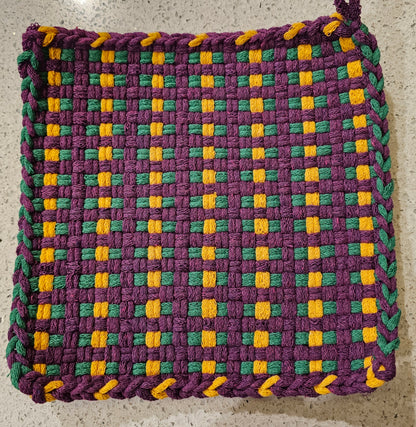 Woven potholder with purple, green, and yellow pattern on a neutral background
