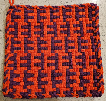 Woven pot holder with orange and purple pattern 