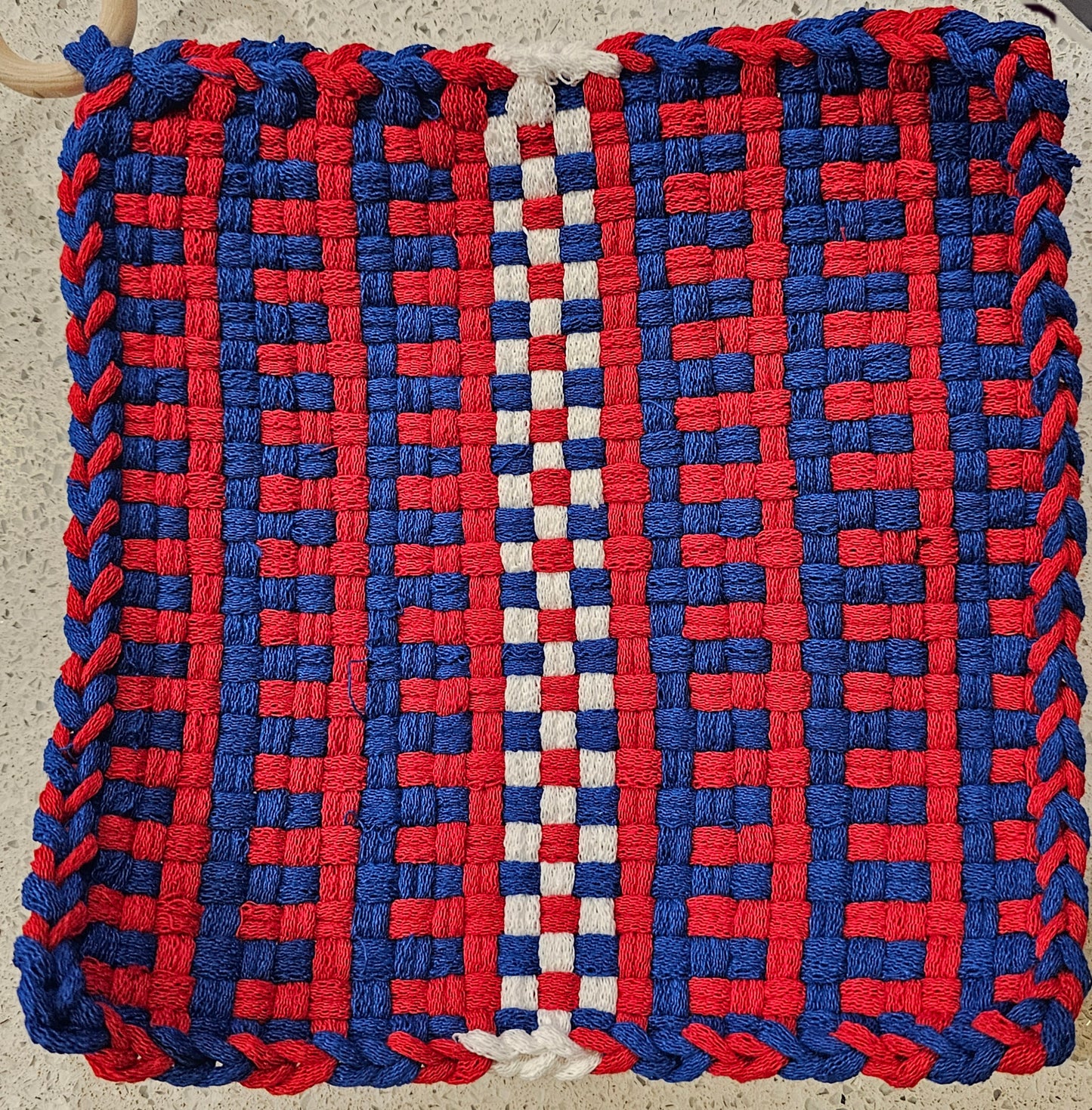 Woven mat with red and blue pattern on a neutral background