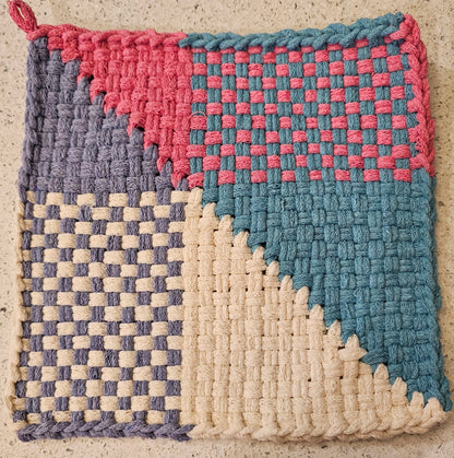 Woven potholder with pink, blue, and cream patterns 