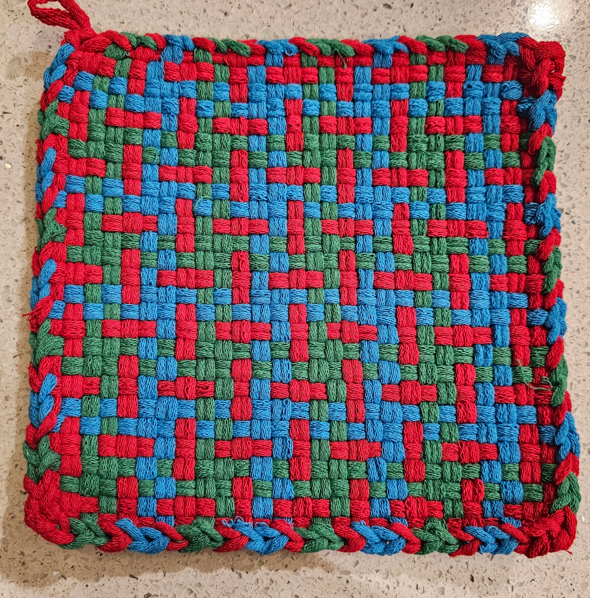 Multicolored woven potholder with red, green, and blue pattern 