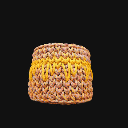 A round crocheted basket in warm brown, beige, and gold tones; featuring a floral cutout lid. 6x6x6 inches overall. Basket opening is 4 inches in diameter.