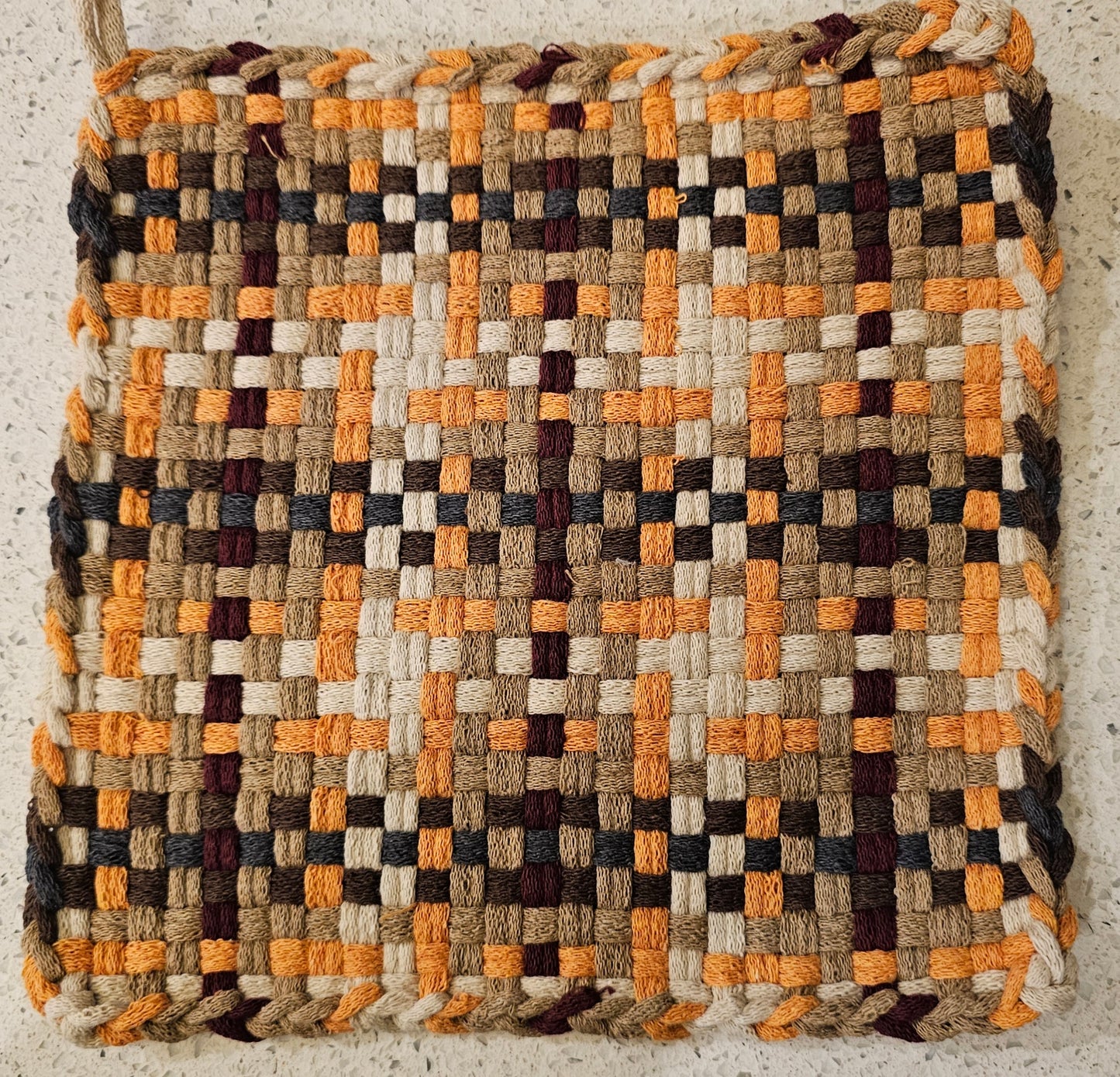 Woven potholder in a geometric pattern in fresh autumn tones 