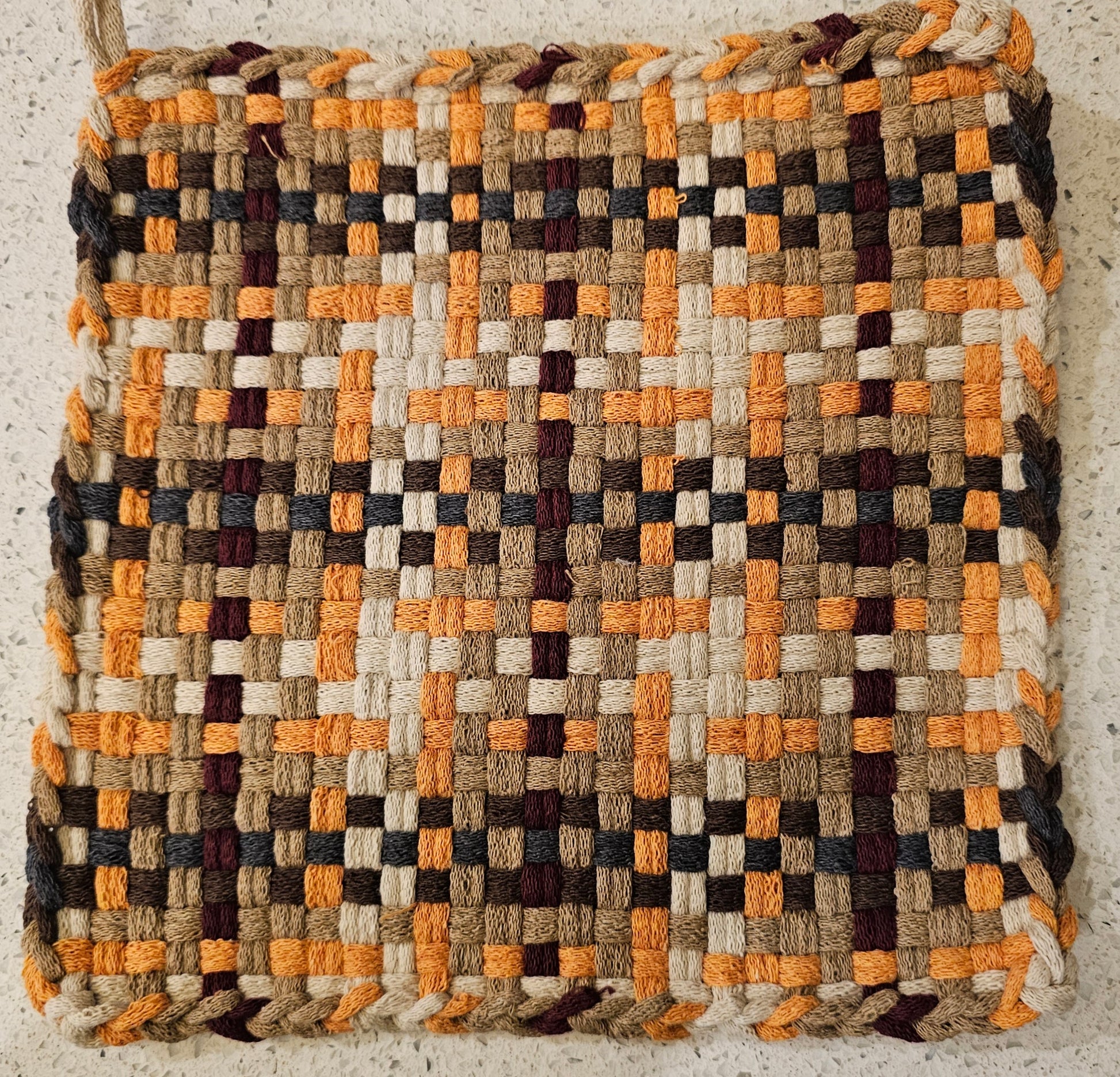 Woven potholder in a geometric pattern in fresh autumn tones 