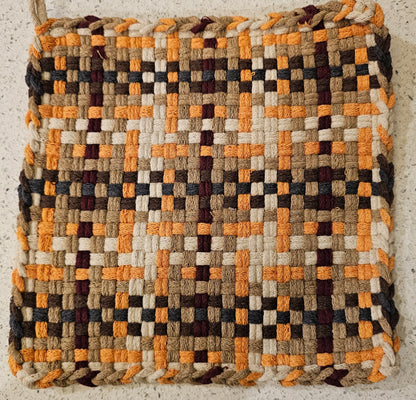 Woven potholder in a geometric pattern in fresh autumn tones 