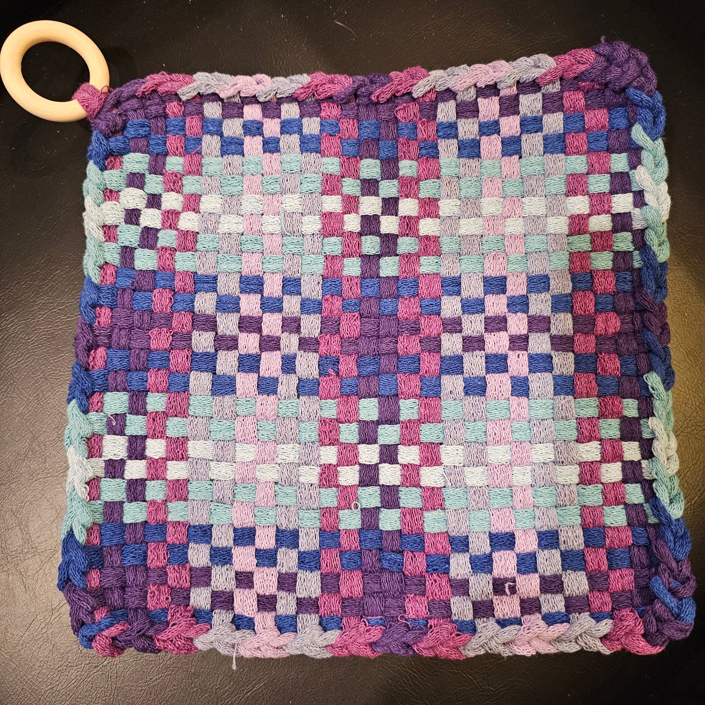 Woven potholder with a checkered pattern in purple, pink, and blue  lavenders