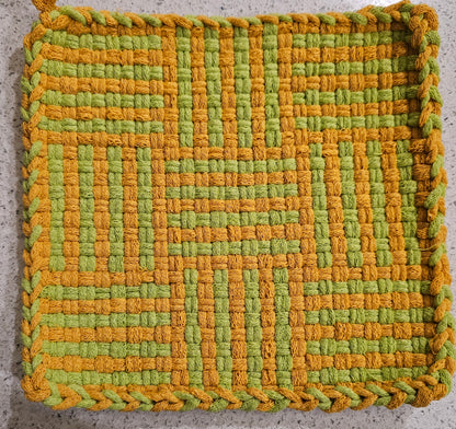 Woven green and orange mat on a textured surface