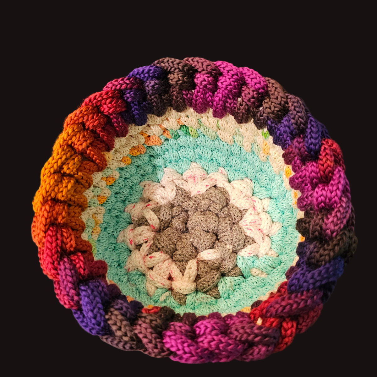 A handmade crocheted round bowl with a vibrant multicolor gradient pattern. This piece is made using leftover yarns from other projects that were knitted together using an i-cord machine; and then hand crocheted to form the bowl. 8x8x4.5 inches overall 