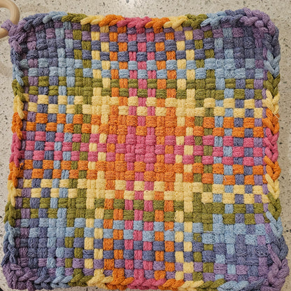 Multicolored potholder  in purples and yellows with a checkered pattern 