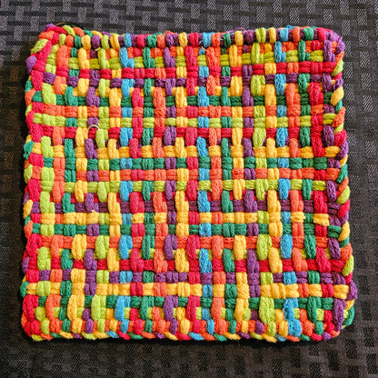 Multicolored woven fabric square on a dark textured background