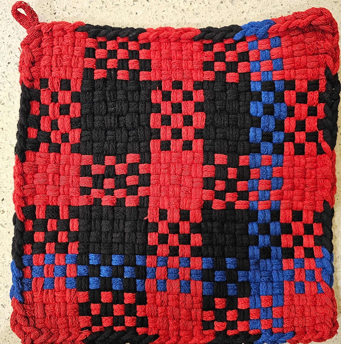 Woven potholder with red, black, and blue pattern 