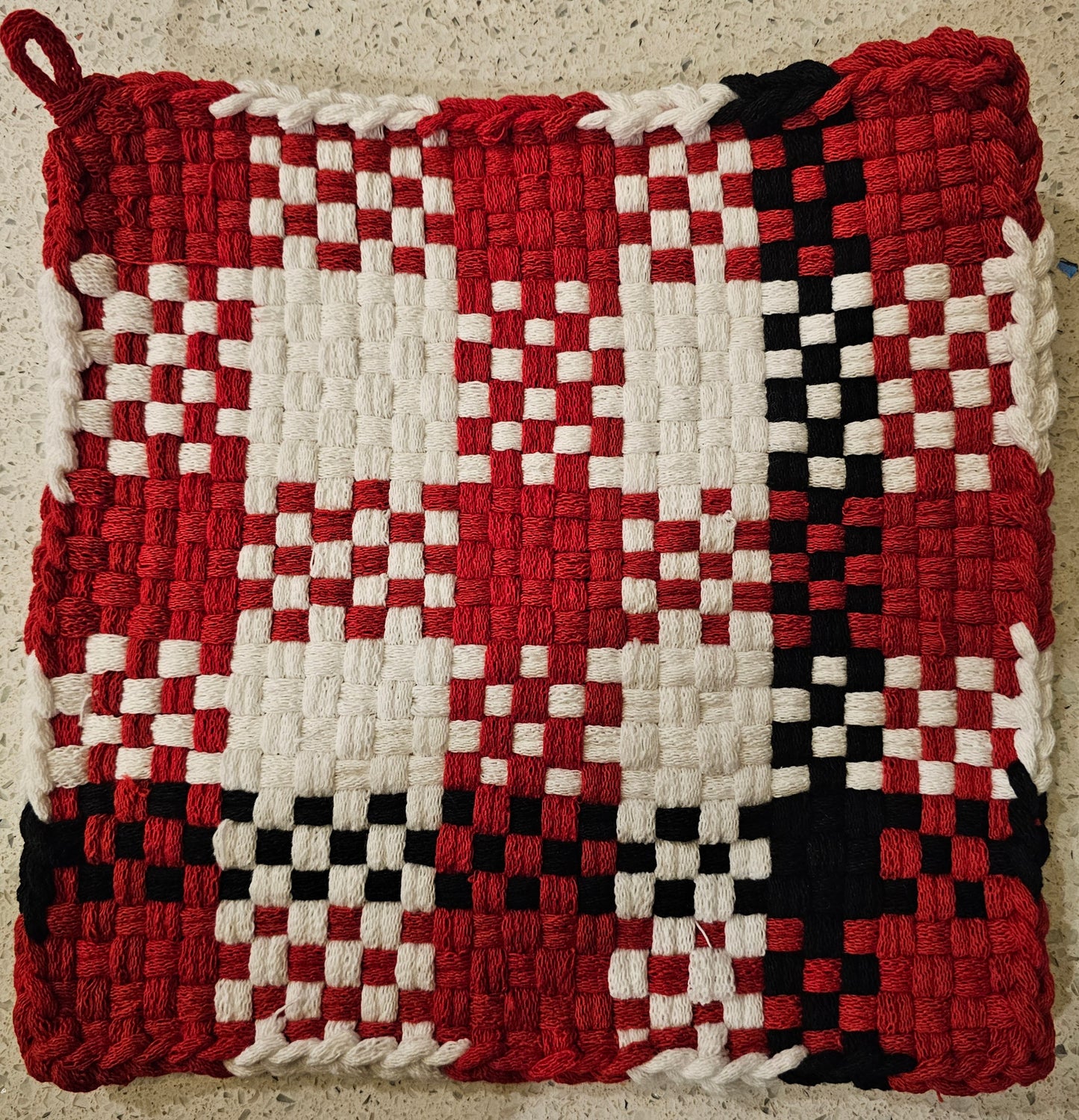 Woven potholder with red, white, and black checkered pattern 