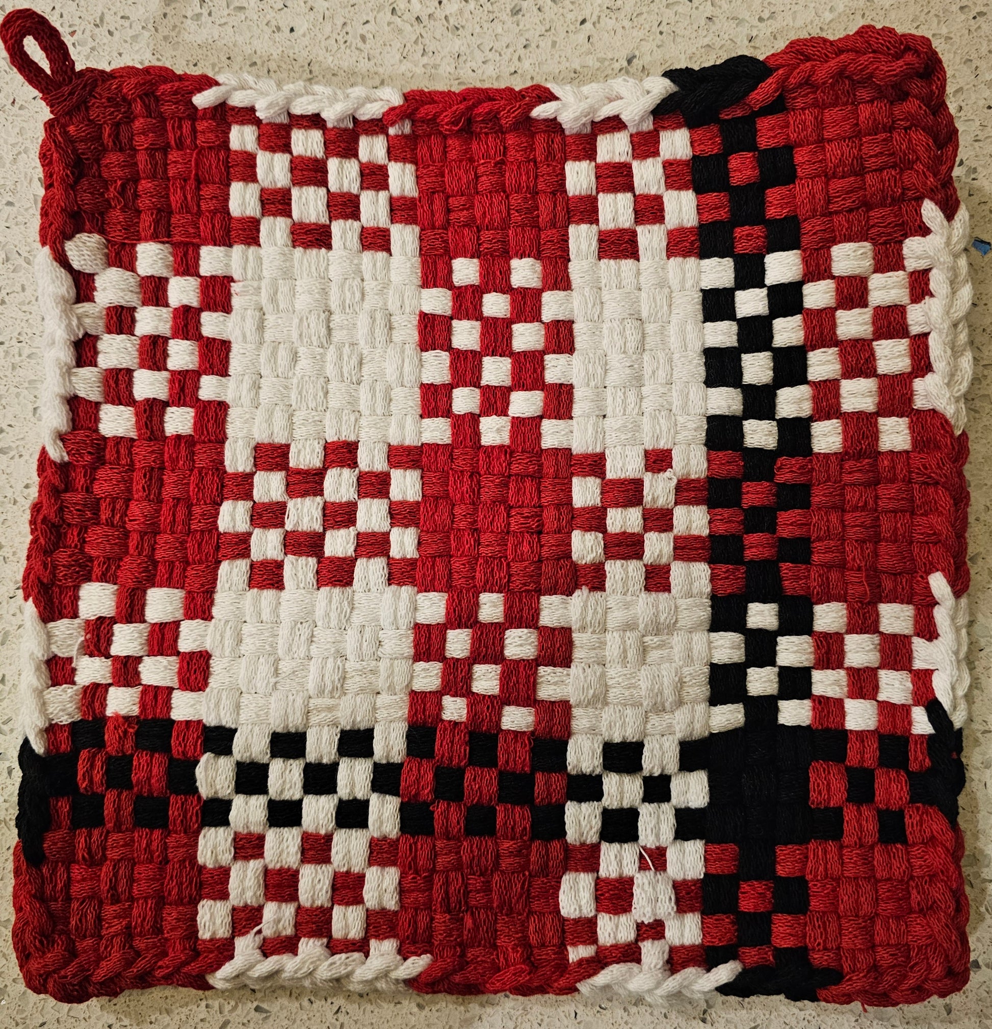Woven potholder with red, white, and black checkered pattern 