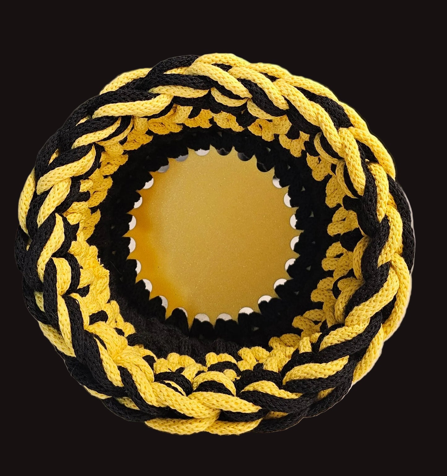 A crocheted mini basket with alternating yellow and black cord on a yellow base. 6x6x3.5 inches overall