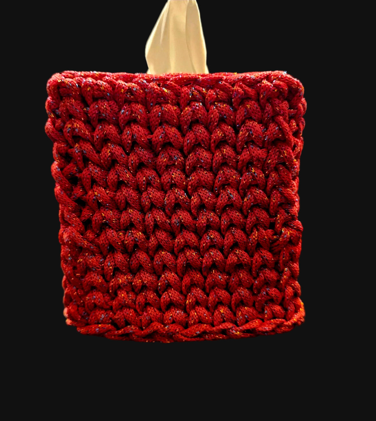 A square tissue box cover with a textured red braided crochet exterior and a beige interior. The cover has subtle multicolor glitter threads woven throughout. 5x5x6 inches overall