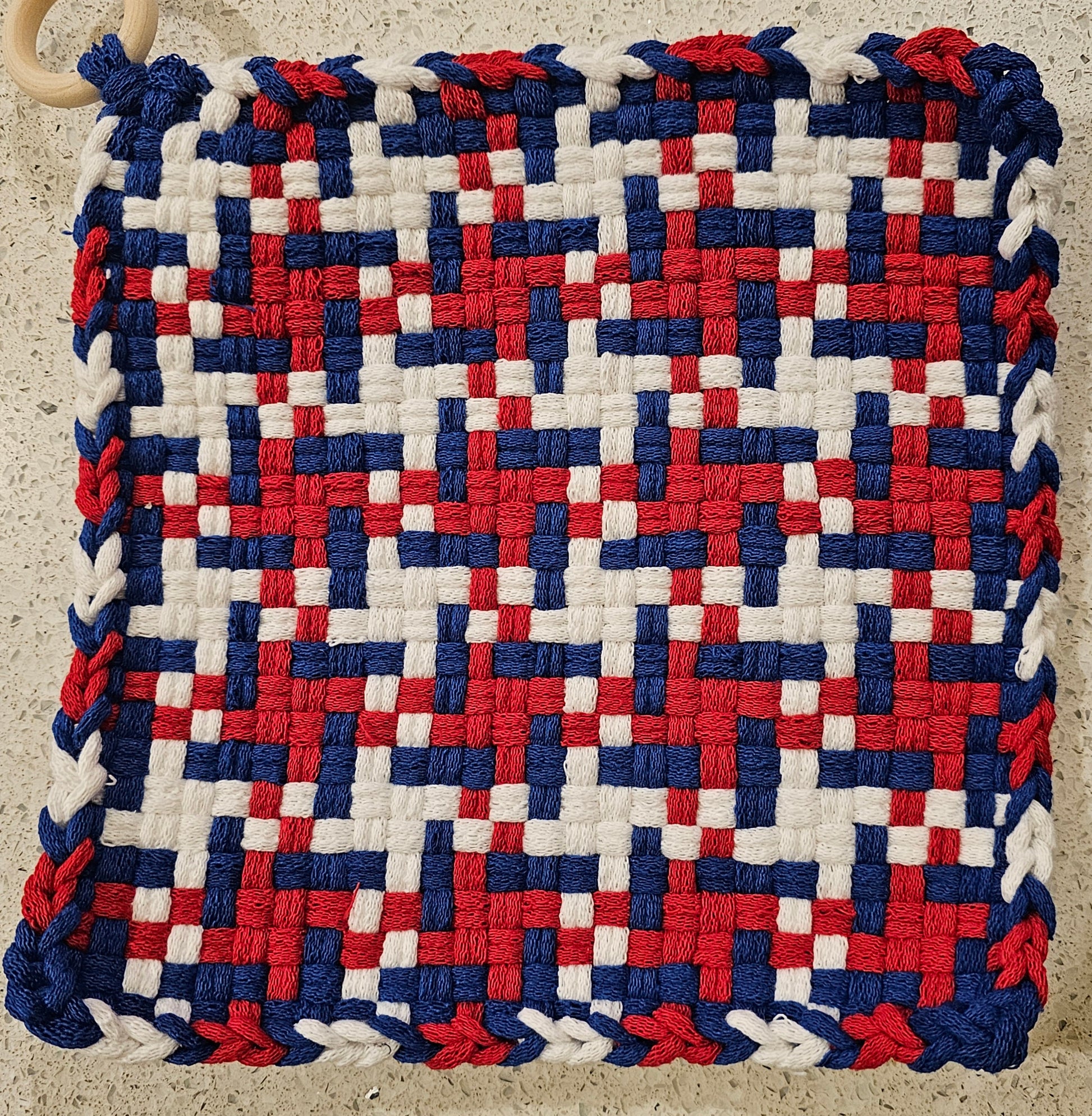 Woven mat with red, white, and blue pattern 