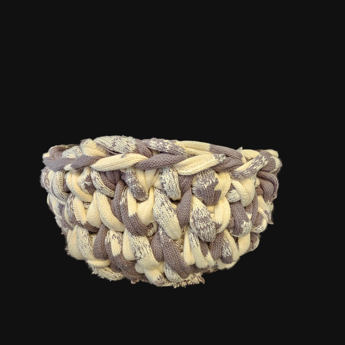 A thick chunky basket made from gray and cream variegated sweater type material. Rustic and irregular in nature. 10x10x5 inches overall