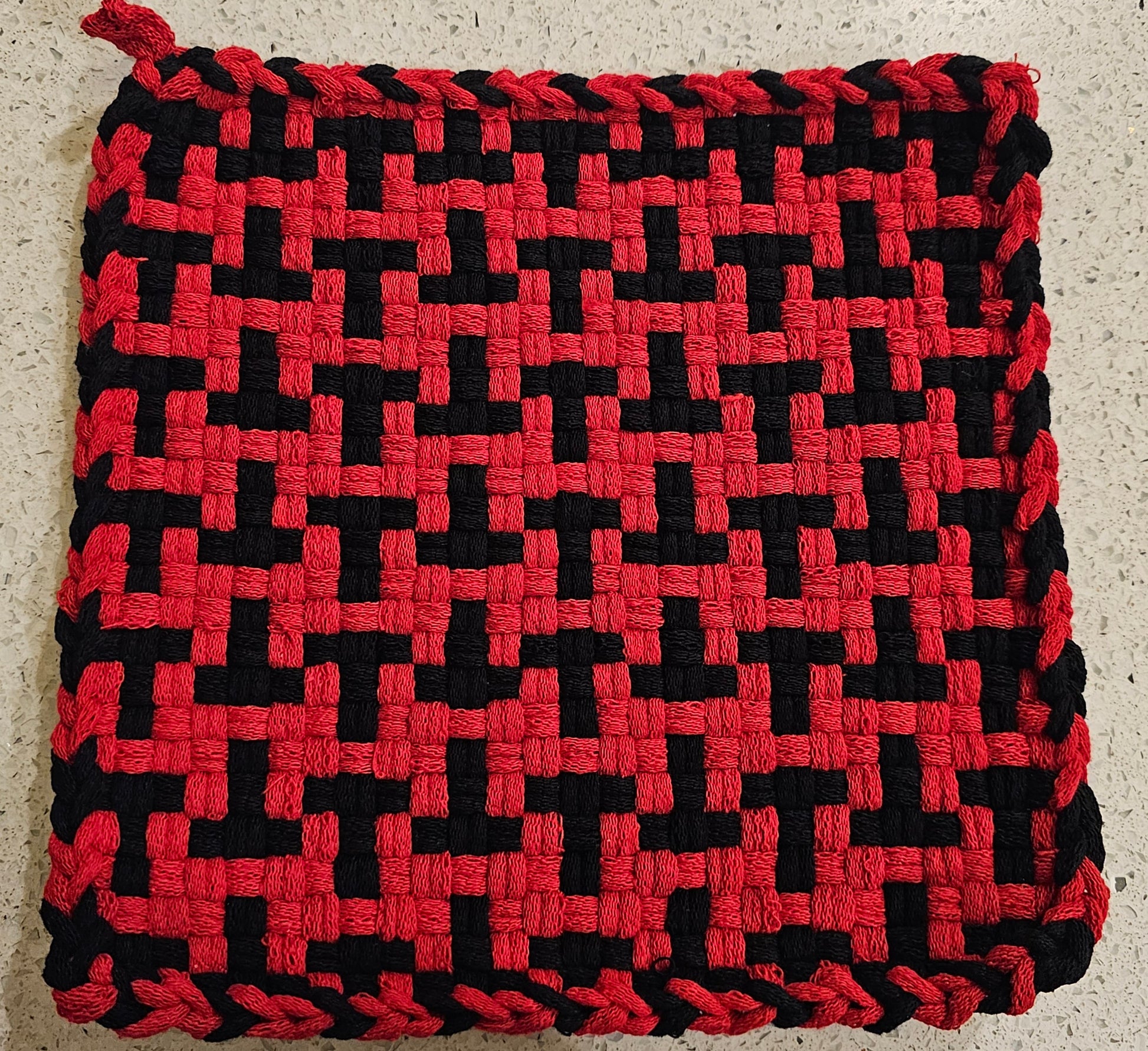 Red and black woven potholder in a "T" formation