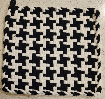 Black and white woven mat on a textured surface