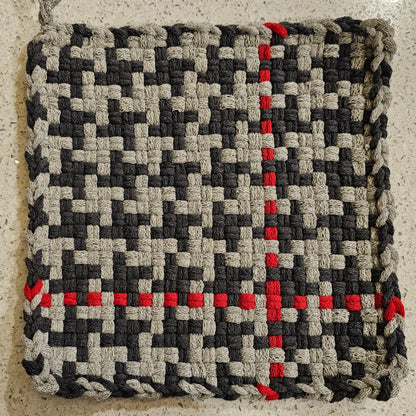 Woven potholder in shades of gray surface
