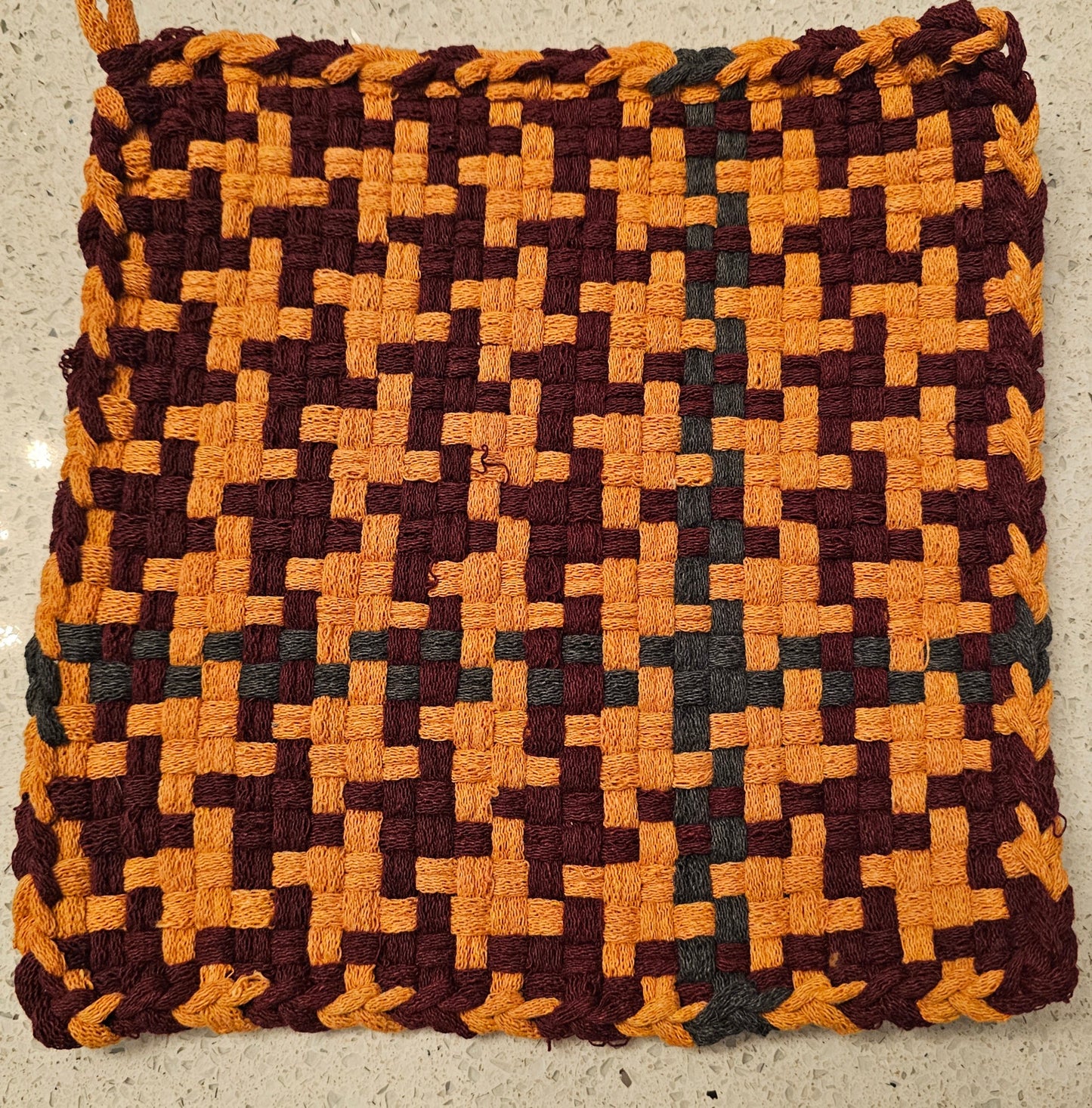 Potholder with a geometric pattern in burgundy and orange