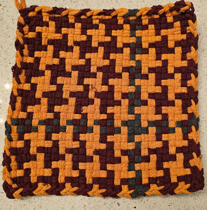 Potholder with a geometric pattern in burgundy and orange